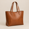 Bolsa tote de cuero café coñac sobre fondo beige de estudio