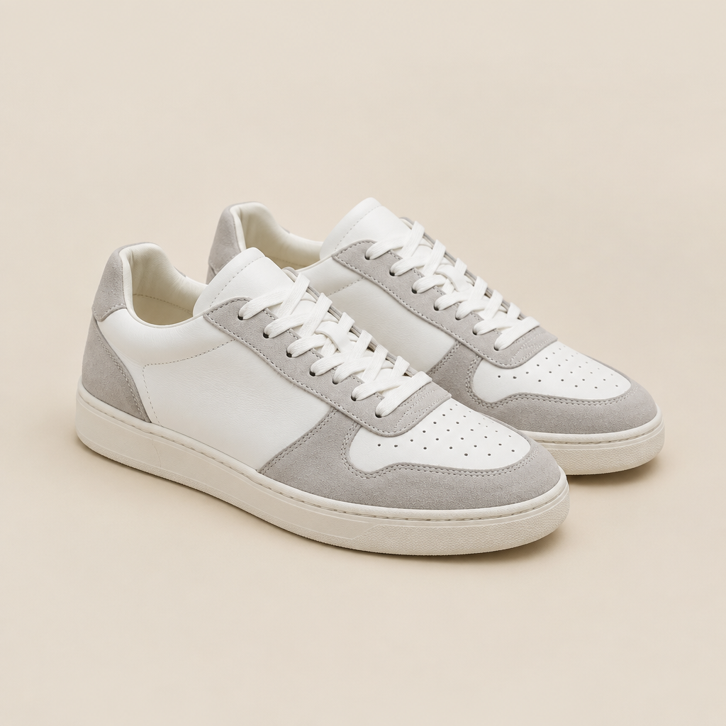 Tenis casuales blancos y grises sobre fondo beige de estudio